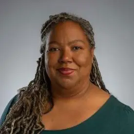 A woman with braided hair smiling.